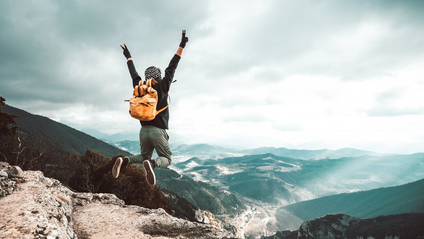 Successful hiker man jumping on the top of the mountain - Successful, business and sport concept. (opens enlarged image) (opens enlarged image)