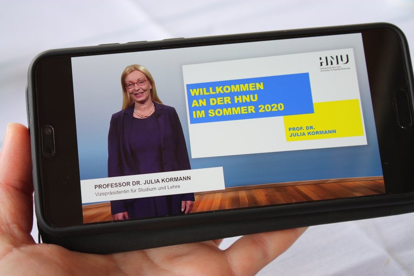 (öffnet Vergrößerung des Bildes) Smartsphone, auf dem das Begrüßungsvideo für Erstsemesterstudierende von Frau Prof. Dr. Julia Kormann gezeigt wird. (öffnet Vergrößerung des Bildes)