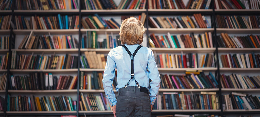 Schmuckbild: Kind vor Bücherwand