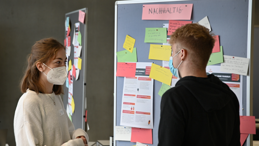 (opens enlarged image) A female student and a male student at a noticeboard. (opens enlarged image)