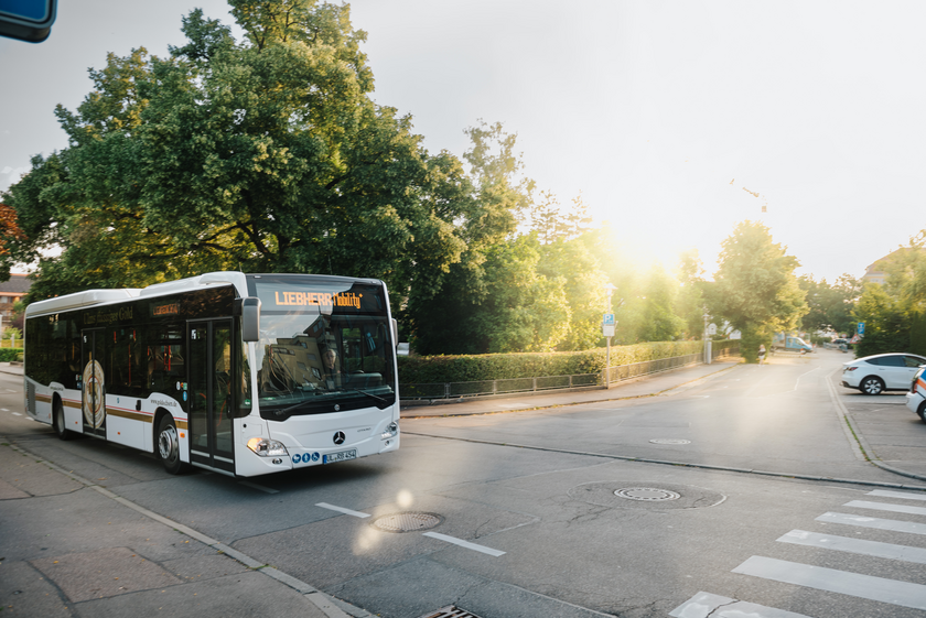 Das Bild zeigt einen Bus, der auf einer Straße fährt.