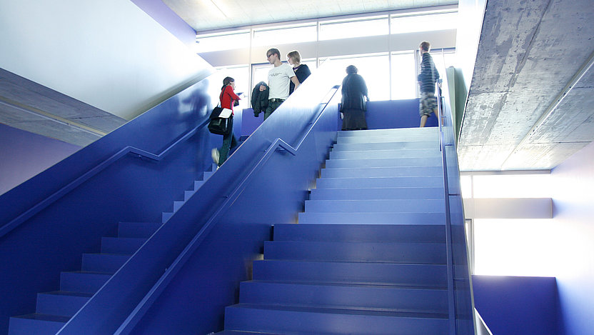 HNU Innenansicht, Studierende im blauen Treppenhaus