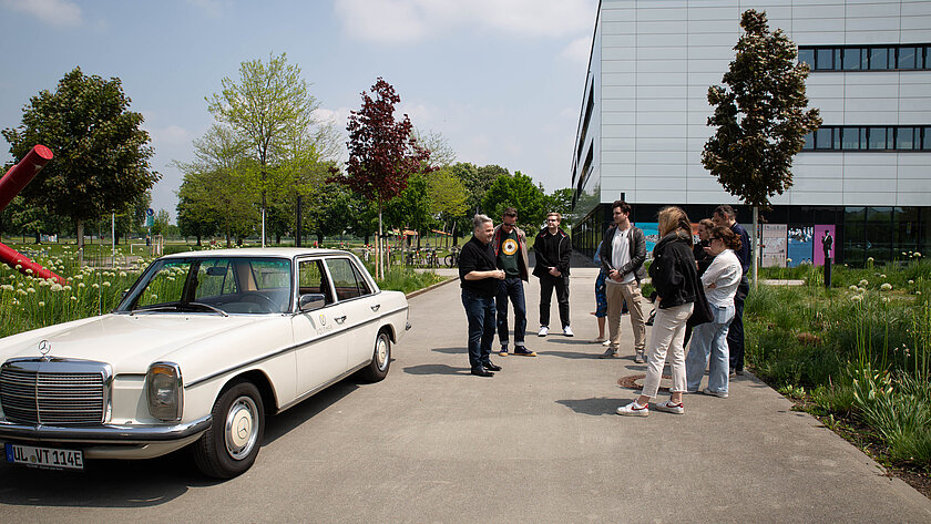Studierende und Professoren auf dem Campus mit Johannes Boddien und seinem Auto. (öffnet Vergrößerung des Bildes)