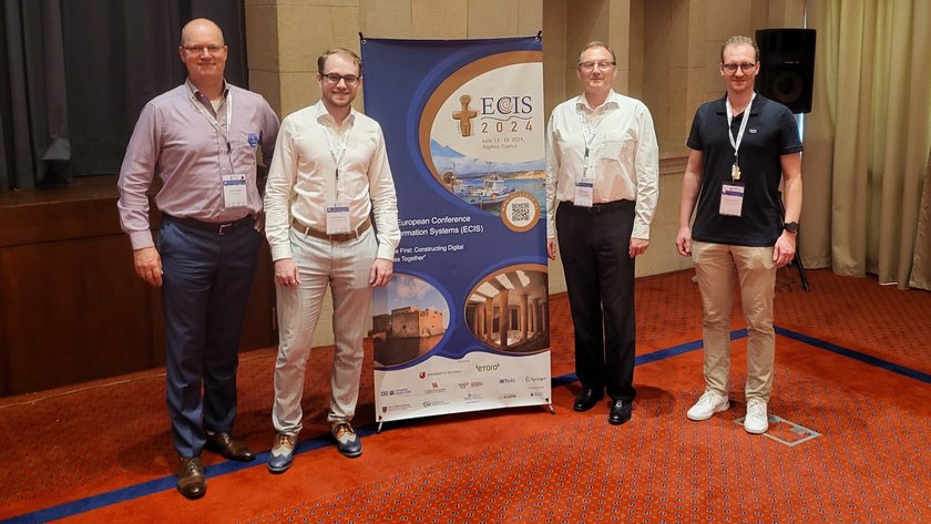 (öffnet Vergrößerung des Bildes) Das IDI-Team auf der ECIS; v.l.n.r.: Prof. Dr. Heiko Gewald, Maximilian Haug, Prof. Dr. Heinz-Theo Wagner, Luca Stegmann. (öffnet Vergrößerung des Bildes)