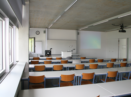 Ein heller und leerer Seminarraum der HNU mit Blick auf die Tafel