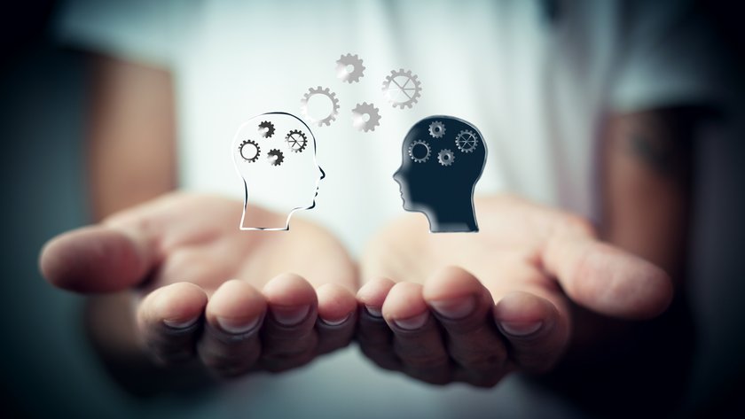 Das Bild zeigt Hände, welche nach oben gerichtet sind. Auf den Händen ist ein menschlicher Kopf als Symbol eingefügt. Von dem Kopf gehen schwarze Elemente auf die andere Hand über. Es könnte eine Informationsübertragung darstellen.