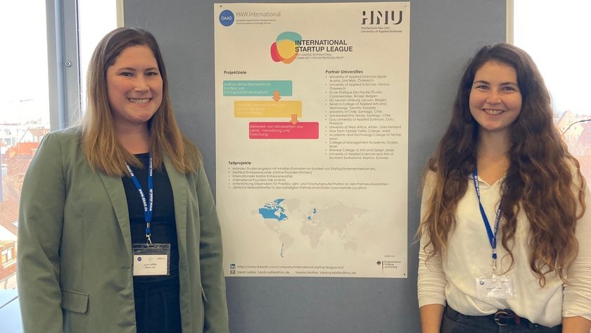 (opens enlarged image) Sarah Leible (left) and Verena Mattes in front of a display wall with a poster about the project. (opens enlarged image)